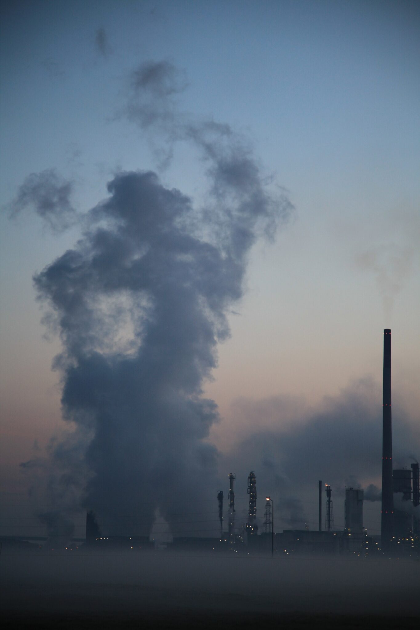 A multiproduct chemical process plant photographed at dawn, showing reaction and distillation trains, structures and interconnecting pipework.