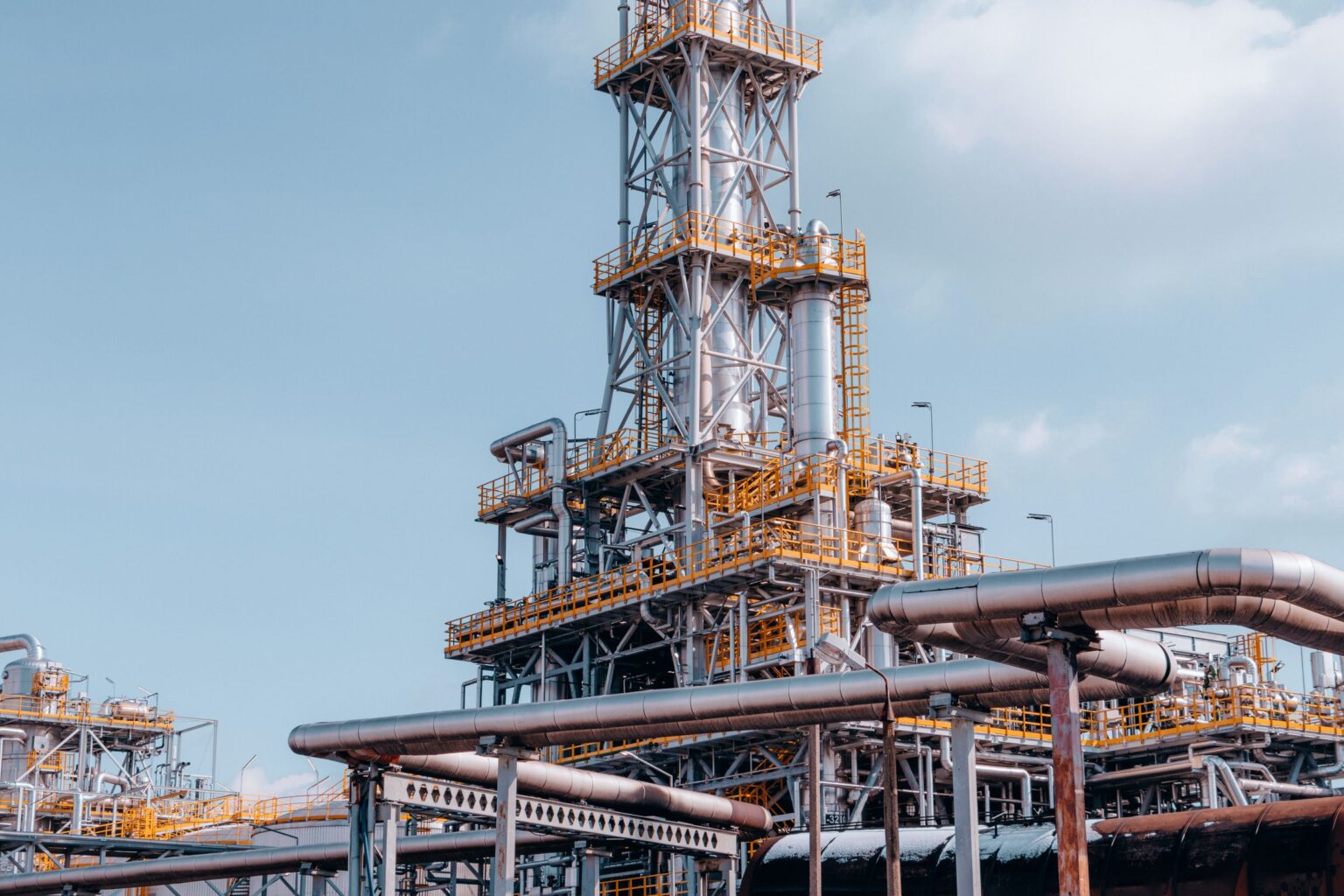 Large bore insulated transfer lines and a tall process column in a natural gas processing plant